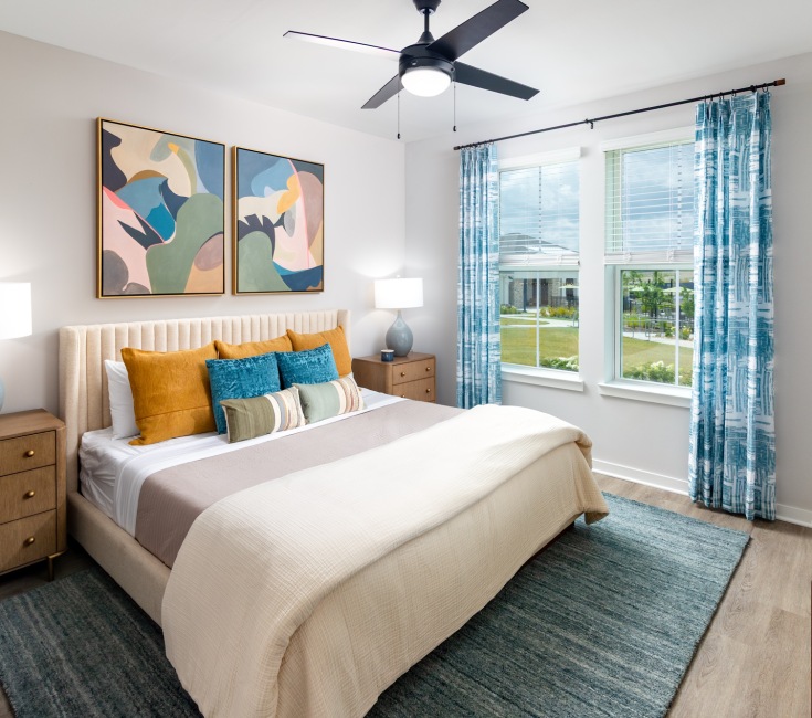 Model bedroom with large bed, two nightstands, and dresser at Elan Smyrna apartments in Smyrna, TN.