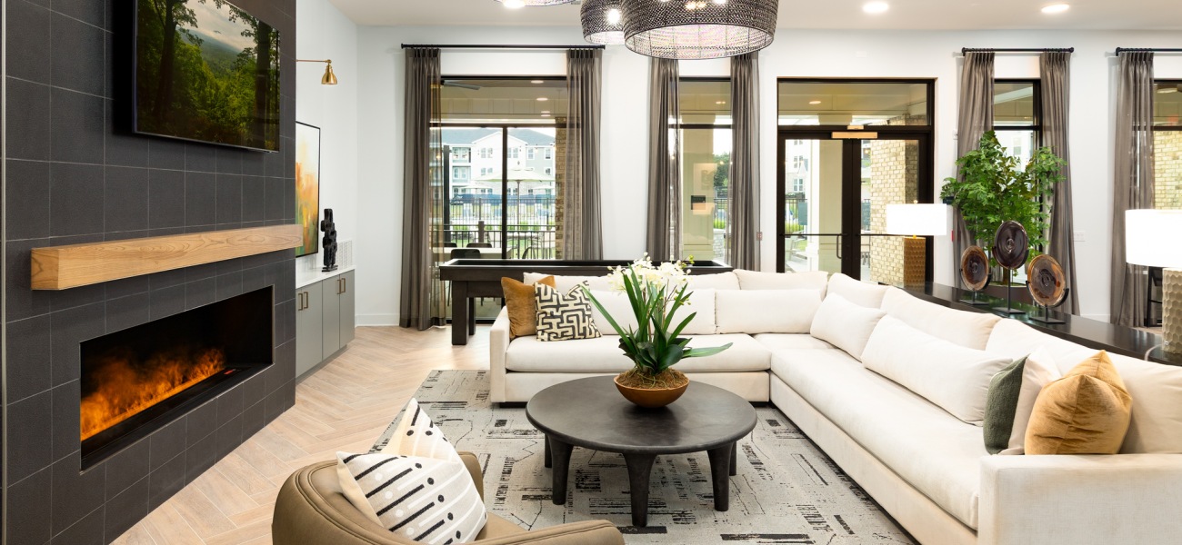 Resident club lounge with large sofa and fireplace at Elan Smyrna luxury apartments in Smyrna, TN.