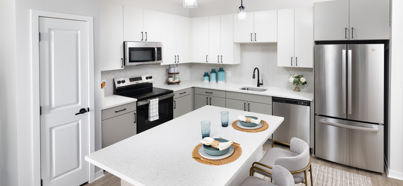 Open kitchen with white cabinets and island at Elan Smyrna new apartments in Smyrna, TN.