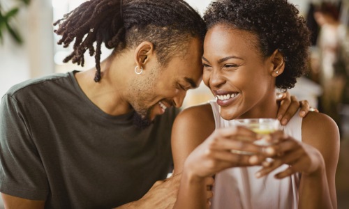 couple close up embracing woman holding coffee smiling couple close up embracing woman holding coffee smiling