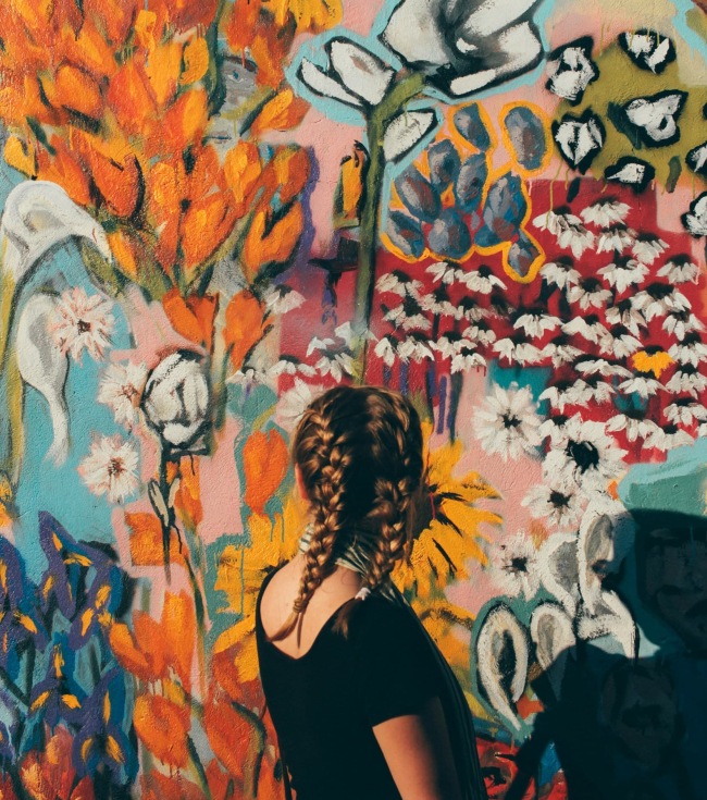 A girl standing in front of colorful wall mural at Elan Smyrna apartments in 37167.